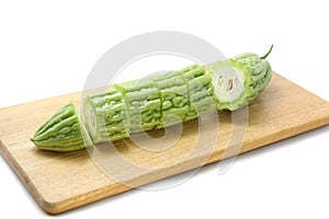 Bitter melon or bitter gourd sliced Ã¢â¬â¹Ã¢â¬â¹on wooden cutting boards on white background.